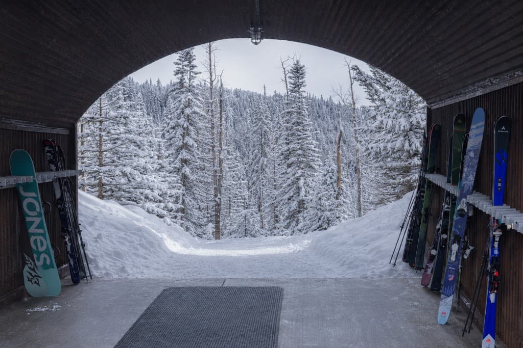 Ski tunnel with gear storage, looking out to snow-covered trees on the Sundance ski run