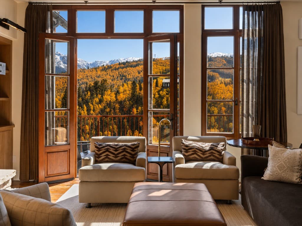 Great room with golden aspens through the glass